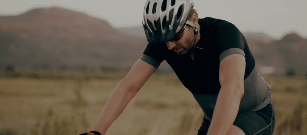 Hombre ciclista pedaleando en bicicleta en la montaña.
