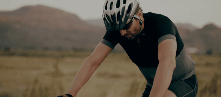 Hombre ciclista pedaleando en bicicleta en la montaña.