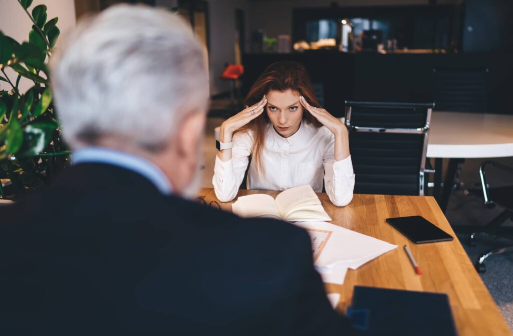 Donna molto irritata a lavoro durante riunione.