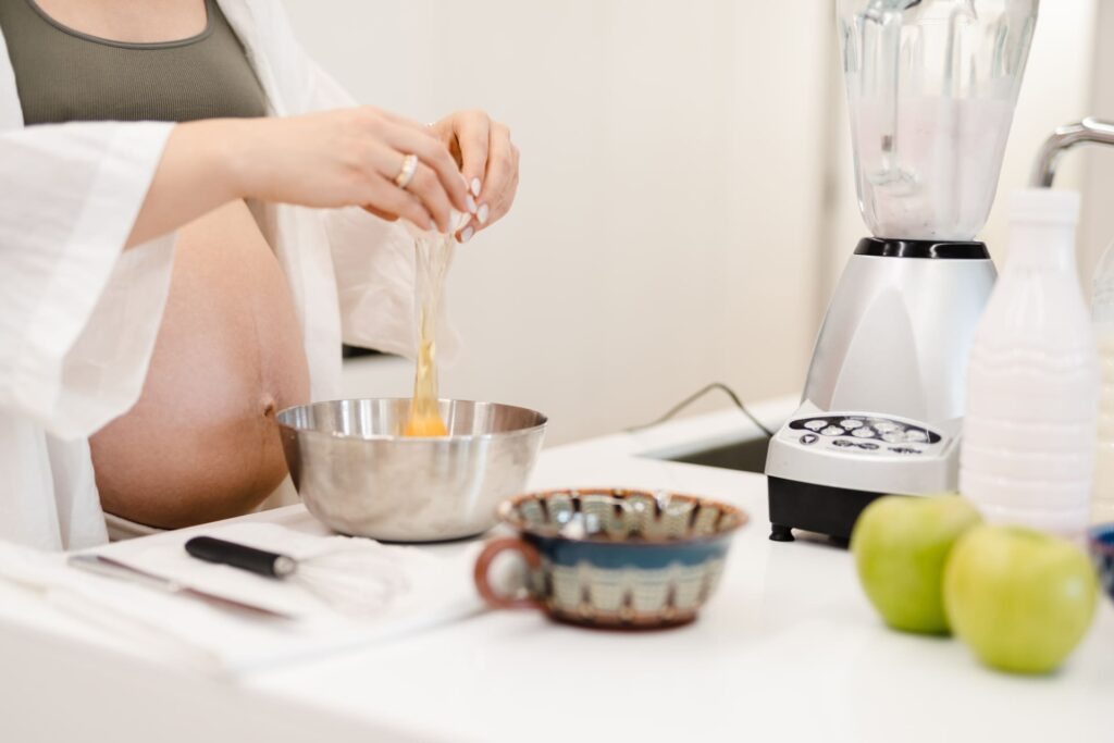 Donna incinta che prepara colazione.