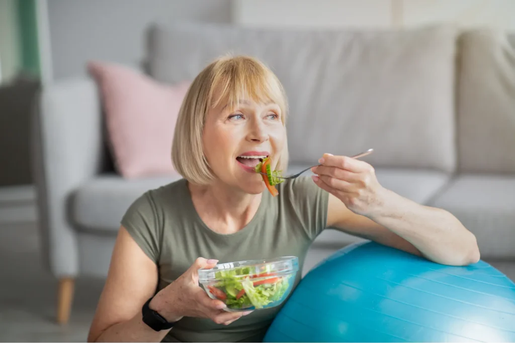 Donna matura che mangia un insalata