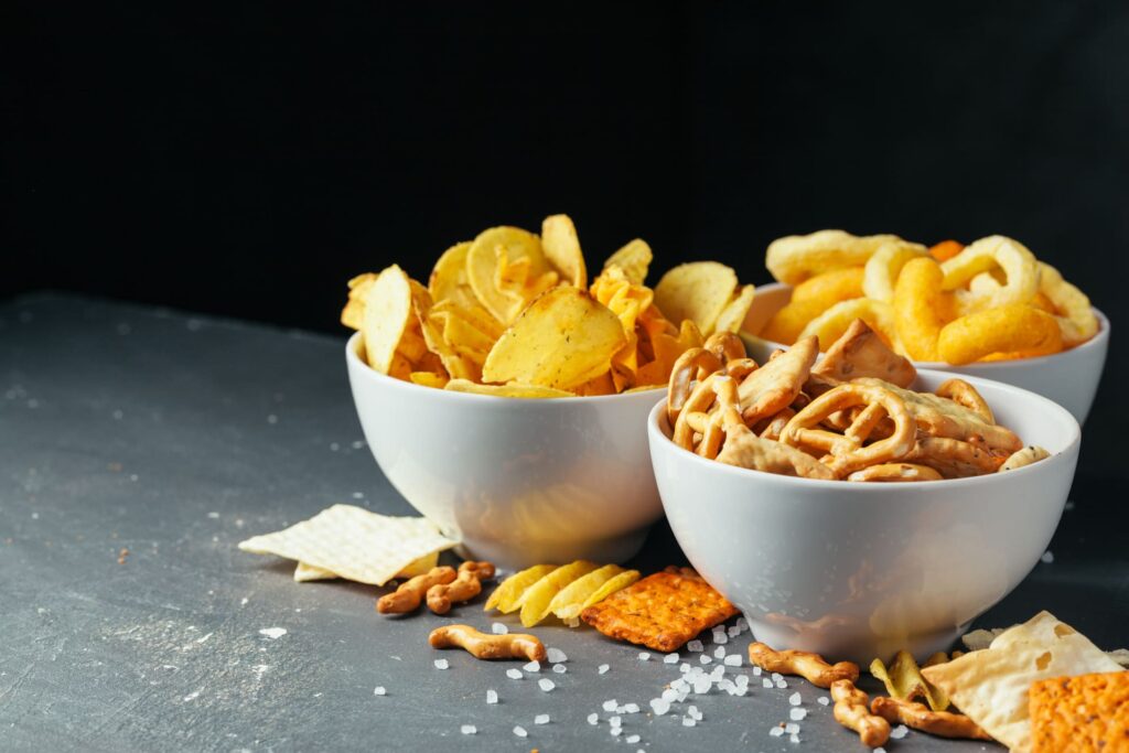 Primo piano di patatine, salatini, snack salati.