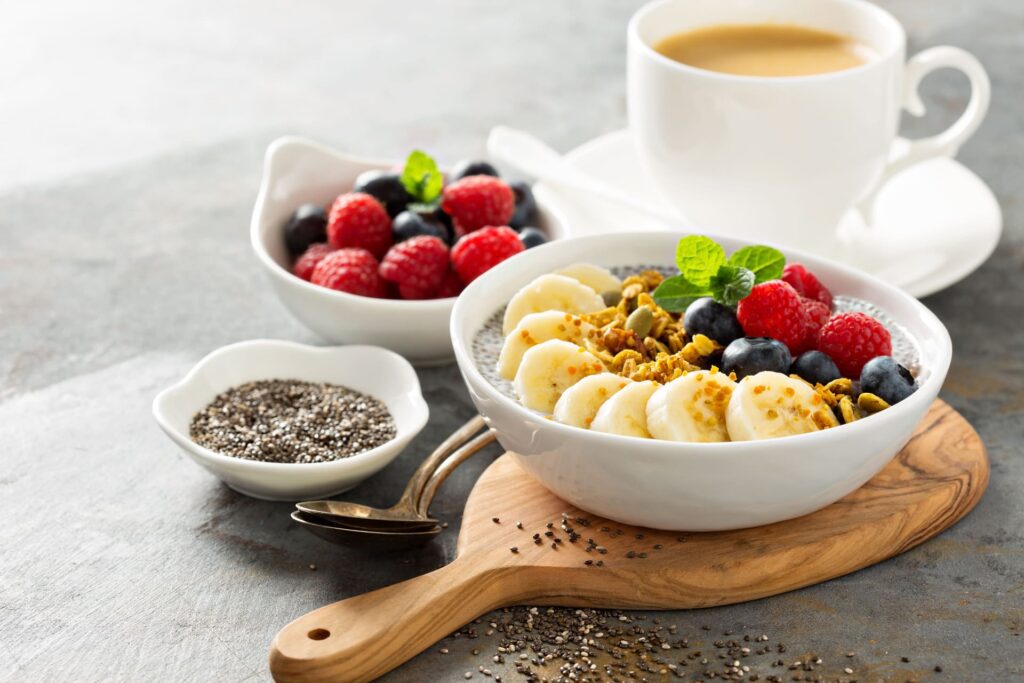 Colazione ricca con yoghurt, banana, frutti di bosco, semi di chia.