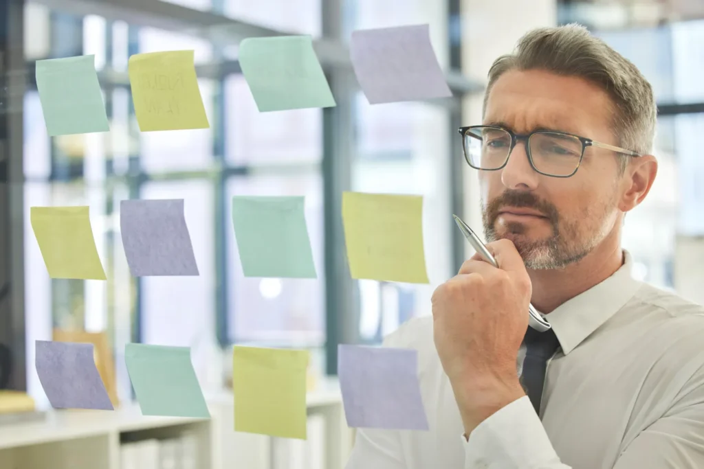 Uomo dubbioso davanti a dei post-it