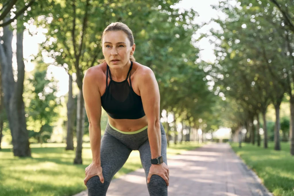 Giovane donna prende fiato mentre fa jogging al parco