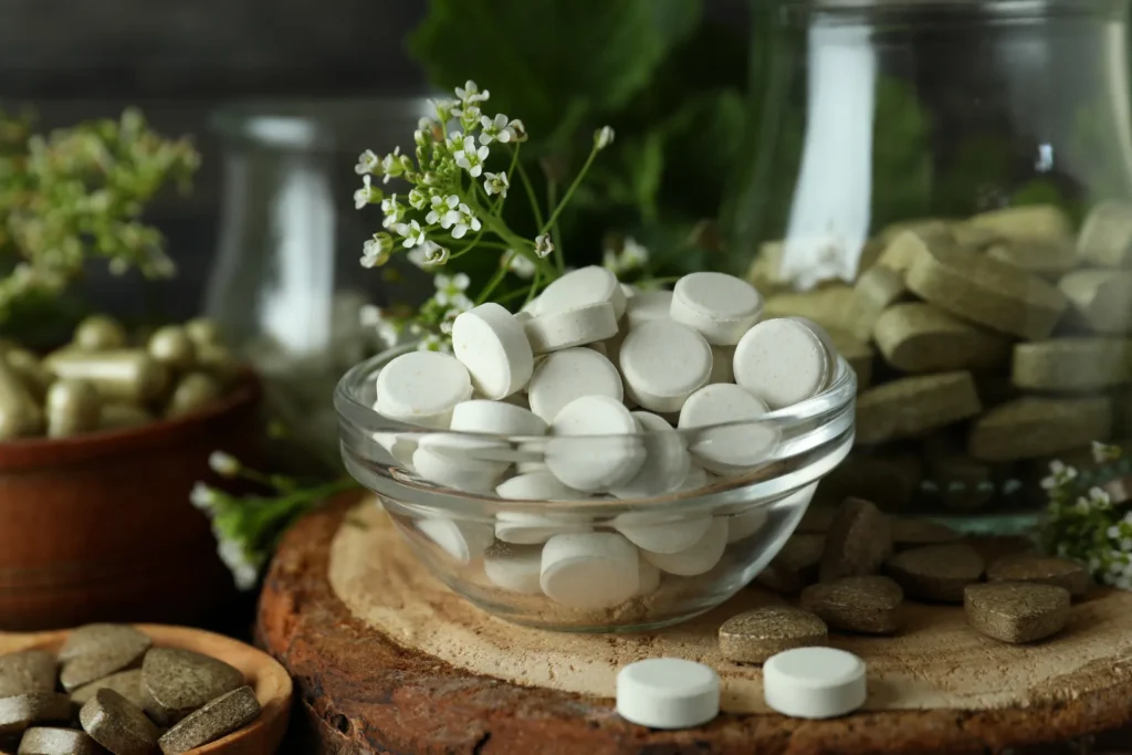 Ciotola con compresse di integratori naturali e rametti di piante
