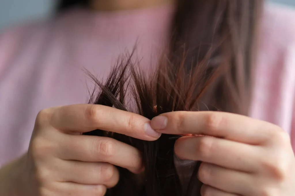 Due mani tengono tra le dita delle ciocche di capelli