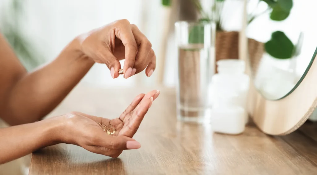 Donna che assume integratori vitaminici con un bicchiere d'acqua