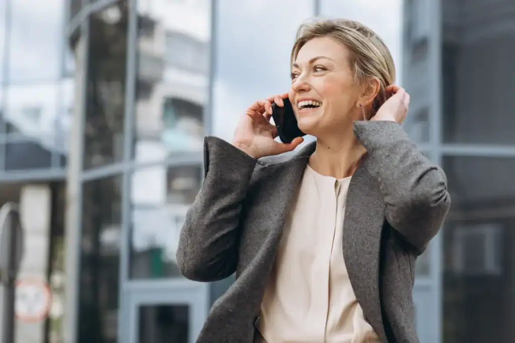 Donna che parla al telefono fuori da un edificio moderno