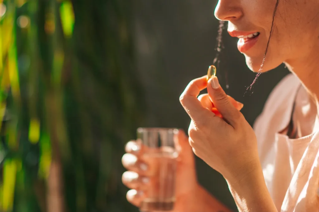 Primo piano di una ragazza che prende una capsula di gelatina vitaminica