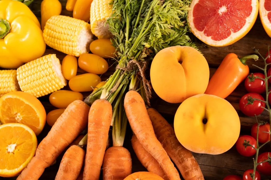 Frutta e verdura varia di colore arancione: peperone, mais, arancia, carote, albicocche