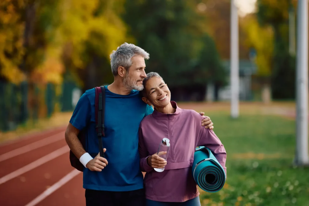 Coppia vestita in modo sportivo che si abbraccia dopo un allenamento