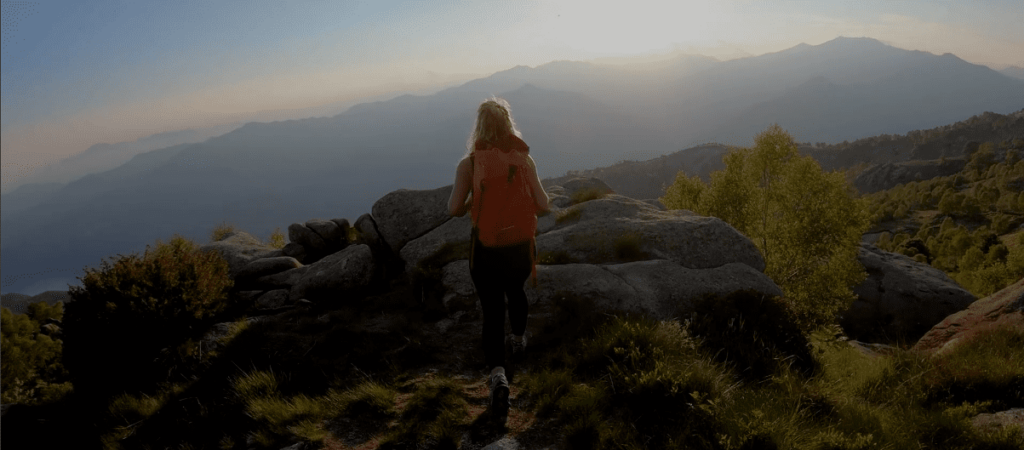 donna di spalle in montagna che pratica trekking
