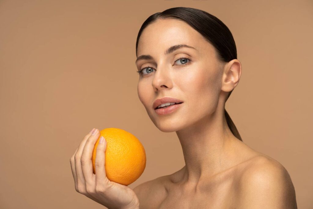 donna con un'arancia in mano